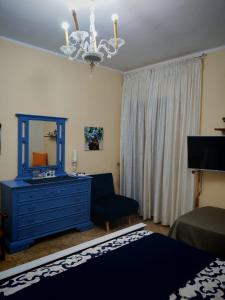 a bedroom with a blue dresser and a mirror at Le stanze di Anna in Capaci +2 photos