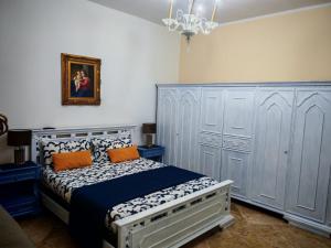a bedroom with a bed with blue cabinets and orange pillows at Le stanze di Anna in Capaci