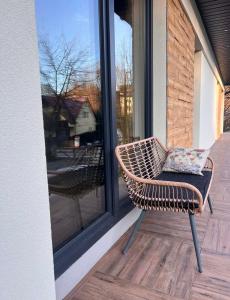 a wicker chair sitting on a porch with a pillow at Stacja Nałęczów 2 in Nałęczów