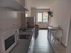 a kitchen with a counter and a table in it at Apartamento tranquilo y luminoso in Mundaka