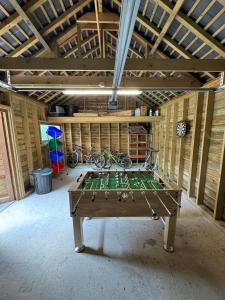 a ping pong table in the middle of a room at La petite maison en Ardenne in Marche-en-Famenne