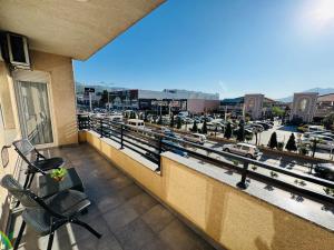 a balcony with chairs and a view of a parking lot at Reinas Apartment in Prizren