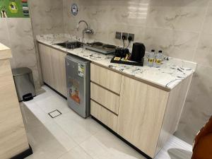 a kitchen with a counter with a sink and a refrigerator at ساتورن هاوس للشقق الفندقية in Tabuk +44 photos