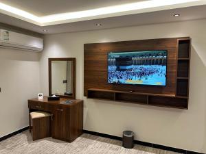 a room with a television on a wall at ساتورن هاوس للشقق الفندقية in Tabuk