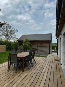 a wooden deck with a table and chairs on it at La petite maison en Ardenne in Marche-en-Famenne