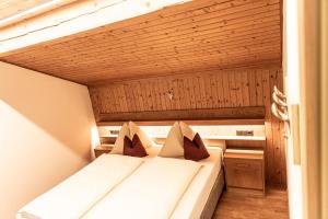 a bed in a small room with a wooden ceiling at Haus Lohengrin Ferienwohnung 5 in Siusi