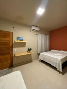 a small bedroom with a bed and a window at Casa Dona Vilma in Barreirinhas