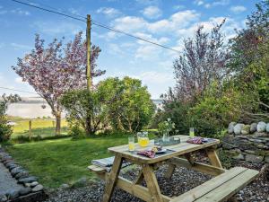 a picnic table in the garden with a view of the water at 1 Bed in Isle Of Arran oc-ca272 in Pirnmill +6 photos