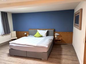 ein Schlafzimmer mit einem Bett und einer blauen Wand in der Unterkunft Ochsen Hardheim in Hardheim + 10 Fotos
