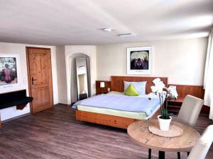 ein Schlafzimmer mit einem Bett und einem Tisch in einem Zimmer in der Unterkunft Ochsen Hardheim in Hardheim