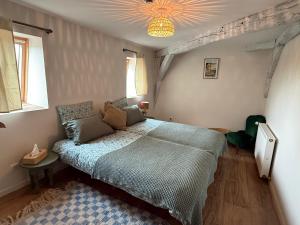 a bedroom with a large bed in a room with windows at L eau douce in Ménétréol-sous-Sancerre