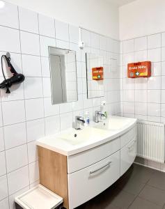 a white bathroom with a sink and a mirror at FAVORIT-ROOMS , direkt Metro connection U1 to Centralstation-Airport and City-Center in Vienna +106 photos
