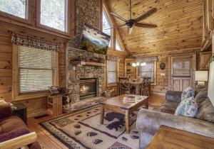 a living room with a fireplace in a log cabin at Mountain Memories Is A Perfect Mountain Getaway For A Family Or Couples Retreat! in Sevierville