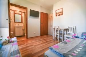a room with a bed and a table and a kitchen at Pod Stokiem in Lubomierz