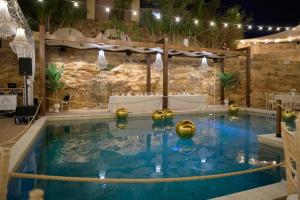 a large swimming pool with a table and chairs at Stenakas Apartments in Chios