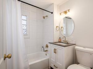 a bathroom with a sink and a toilet and a mirror at Charming 3BD 2BR Dog Friendly in Overland Park +7 photos