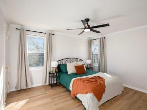 a bedroom with a bed and a ceiling fan at Charming 3BD 2BR Dog Friendly in Overland Park
