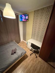 a bedroom with a bed and a desk and a tv at Host-X Pokoje Ciche Centrum Mała Sienkiewicza -fv in Kielce