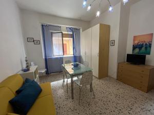 a living room with a yellow couch and a glass table at La casa del professore libeccio in Nicotera Marina