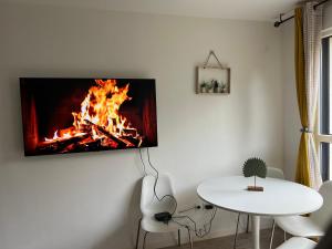 a living room with a fire on the wall at Patty Home Stay in Carrières-sous-Poissy