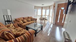 a living room with two couches and a glass table at Enoturismo-Noja in Noja