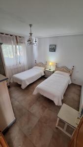 a bedroom with two beds and a chandelier at Enoturismo-Noja in Noja +8 photos