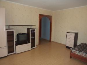 an empty living room with a tv and a couch at Apartment on Komsomolskaya 8 in Kirov