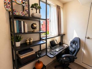 an office with a desk with a chair and a laptop at Habitación individual con baño privado a 3 Min del Estadio Azteca-Banorte y muy cerca de zona de hospitales in Mexico City