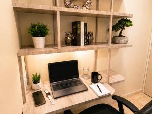 a wooden desk with a laptop computer on it at Habitación individual con baño privado a 3 Min del Estadio Azteca-Banorte y muy cerca de zona de hospitales in Mexico City