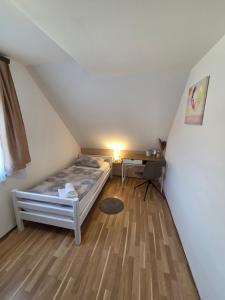 a bedroom with a bed and a desk in a attic at Apartments Luka in Rakovica