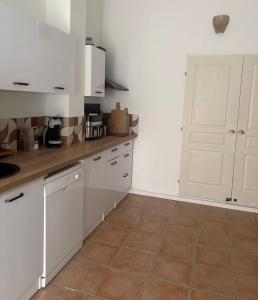 a kitchen with white cabinets and a tile floor at Villa la serella in Brando