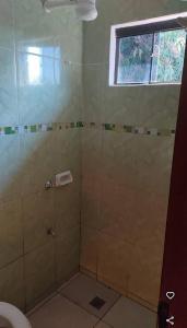 a bathroom with a shower with a toilet and a window at Marina Hotel in Ciudad del Este