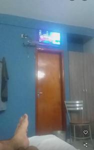 a person laying on a bed in front of a brown door at Marina Hotel in Ciudad del Este