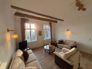 a living room with two couches and a tv at Gutshaus Redentin in Krusenhagen