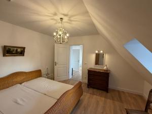 a bedroom with a bed and a chandelier at Gutshaus Redentin in Krusenhagen
