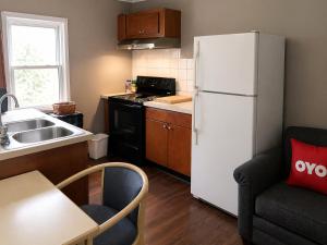 a small kitchen with a white refrigerator and a table at OYO Hotel Starlite Seneca Falls in Seneca Falls
