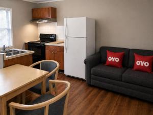 a kitchen with a black couch and a white refrigerator at OYO Hotel Starlite Seneca Falls in Seneca Falls +36 photos