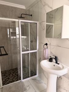 a bathroom with a shower and a sink at Oregano Estate in Swakopmund +5 photos