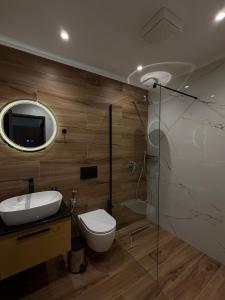 a bathroom with a toilet and a sink and a mirror at Lumera Hotel in Durrës +137 photos