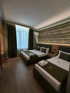a hotel room with two beds and a window at Lumera Hotel in Durrës