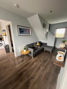 a living room with a couch and a table at Atlantic way Apartment 1 in Breaghwy