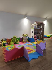 a childs bedroom with a colorful bed with stuffed animals at Šumski Miro in Perućac