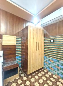 a bathroom with wooden cabinets and a tiled floor at PARADISE VILLA Near Prem Mandir in Vrindāvan +55 photos
