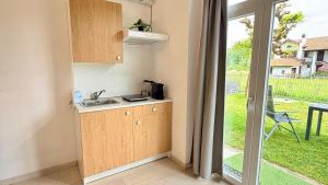 a small kitchen with a sink and a door to a yard at Casa Buda 2BR Apartment-Lakes Malpensa MXP 24h Check-in Parking in Sesto Calende