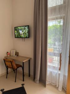 a room with a table and a window with a television at Porta E Gjelbër in Përmet +24 photos