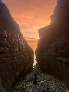 a person standing on a rocky path in a canyon at Atlantic way Apartment 1 in Breaghwy