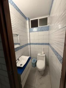 a bathroom with a white toilet and a sink at Casa en Tonsupa in Tonsupa
