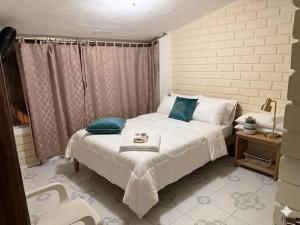 a bedroom with a white bed with blue pillows at Casa en Tonsupa in Tonsupa
