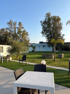 a white table and chairs in a park at Residence Toscano in Palmi