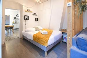 a bedroom with a bed and a blue couch at Au Bretzel Doré - Centre Historique in Colmar
